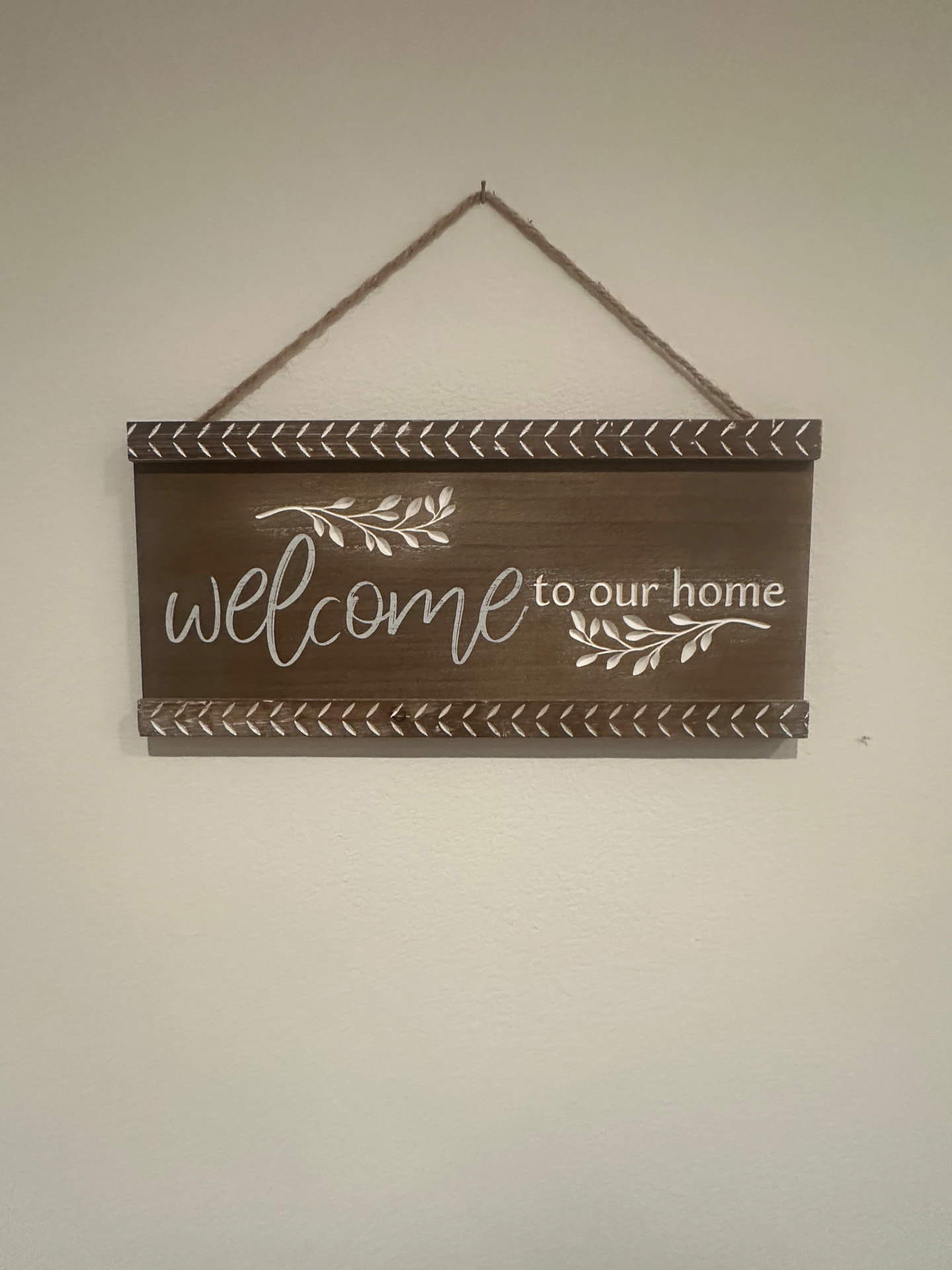 A wooden sign in the entry that reads "welcome to our home"
