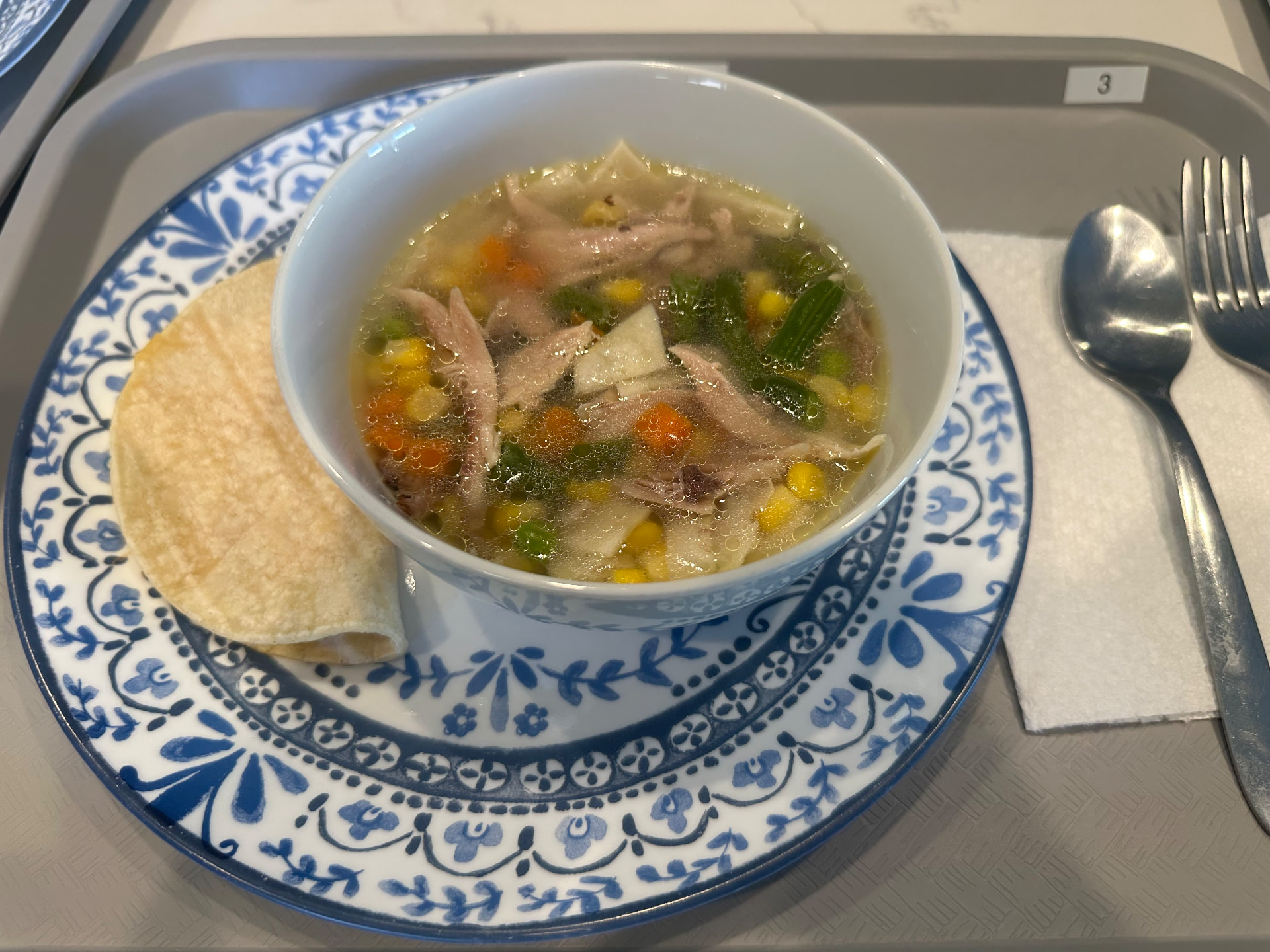 Home-cooked chicken soup served on a resident meal tray